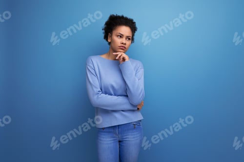 Preview: thoughtful young brunette woman with afro curls thinking about an idea