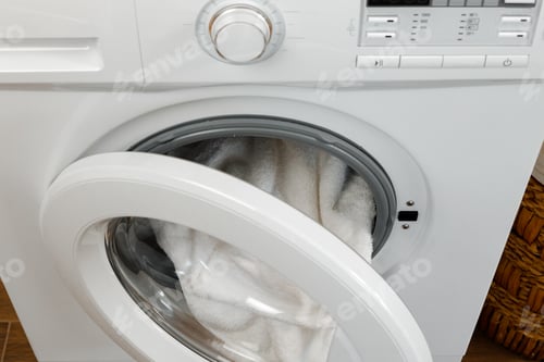 Preview: Washing machine with laundry on blue wall background