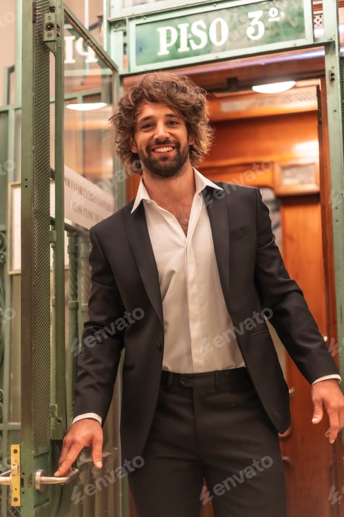 Preview: Street style with a young dark-haired caucasian man in a black suit