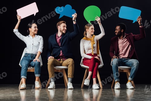 Preview: happy multiethnic people holding speech bubbles and thought bubble isolated on black