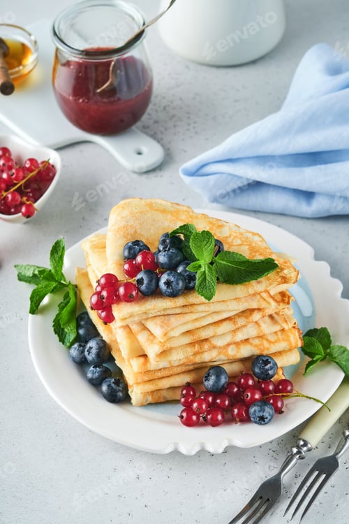 Preview: Pancakes. Stack of crepes or thin pancakes with berries, blueberries, red currants, raspberries and