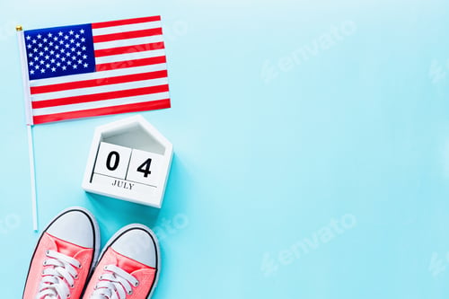 Preview: July 4th. Mockup of july 4 wooden color calendar and USA flag on blue background. Copy space for