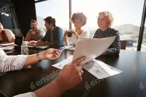 Preview: Papers in hands of man explaining plan to creative team