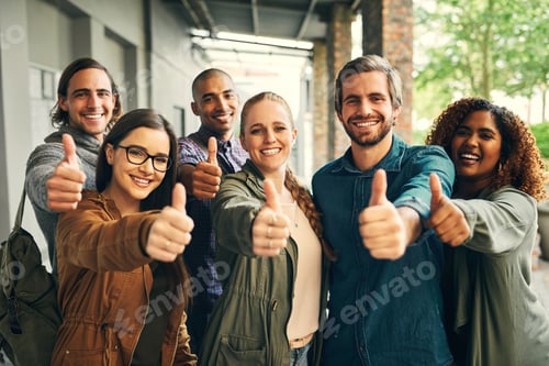 Preview: Portrait of a group of happy young students giving thumbs up together on campus