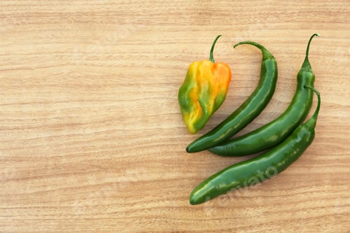 Preview: Different fresh ripe peppers on wooden table, flat lay. Space for text