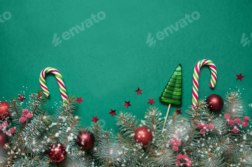 Preview: Christmas tree branches, candy cane and red glass balls on green background