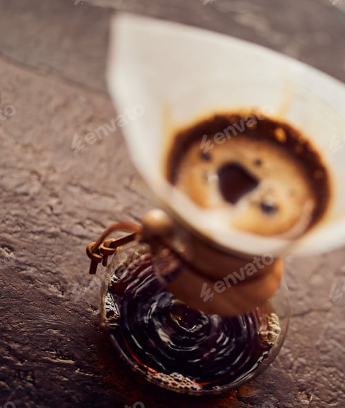 Preview: Vertical shot of boiling coffee in a blurred coffee brew with bubbles and sunlight on it