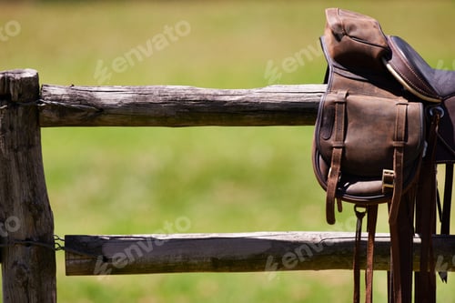 Preview: Hinting at the open plains. Cropped shot of a saddle on a fence.