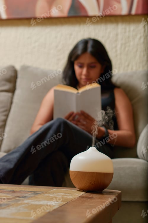 Preview: Young Latina woman reads a book while using aromatherapy.