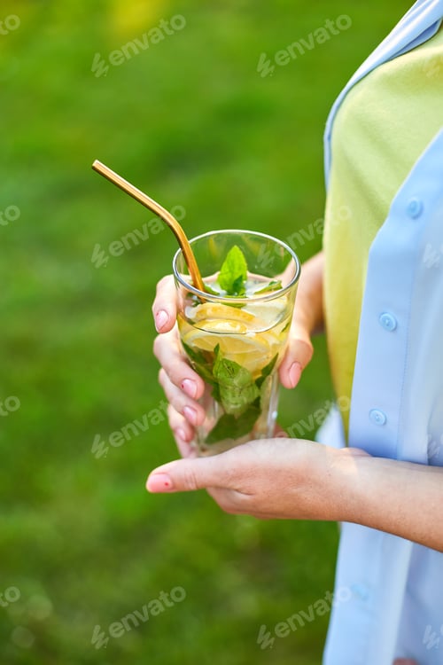 Preview: Woman drinking summer citrus lemonade with reusable metal straws party