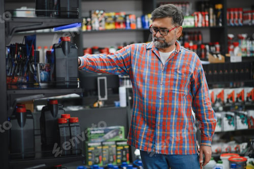 Preview: Mechanic choosing engine oil in auto parts store