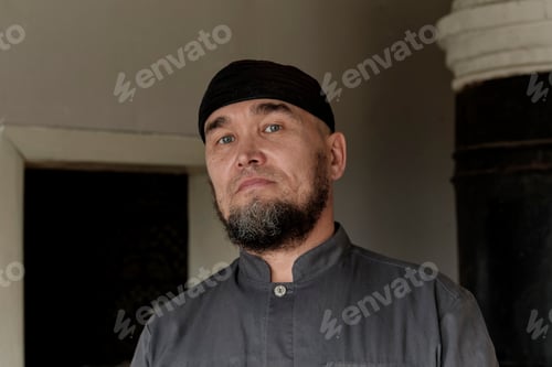 Preview: Portrait of serious senior asian man wearing skullcap. looking at camera