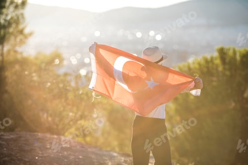 Preview: Person Holding Flag on Hill at Sunset