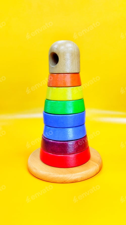 Preview: A toy rainbow pyramid on yellow background