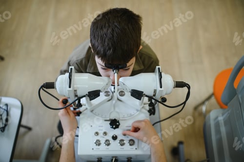 Preview: Ophthalmologist examining child's vision with modern equipment in clinic