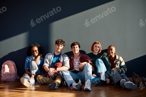 Preview: Group of university students relaxing on the floor and looking at camera.