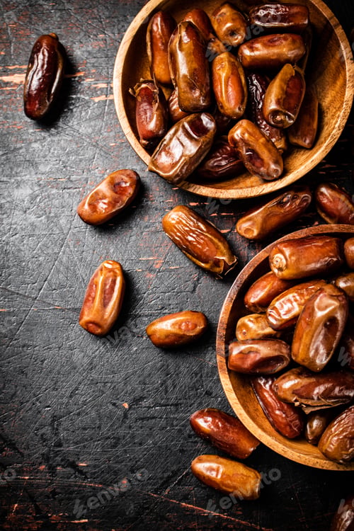 Preview: Delicious dates on a wooden plate.
