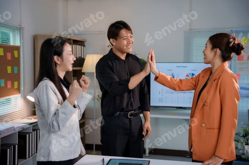 Preview: Asian businesspeople high fiving celebrating successful teamwork in office meeting