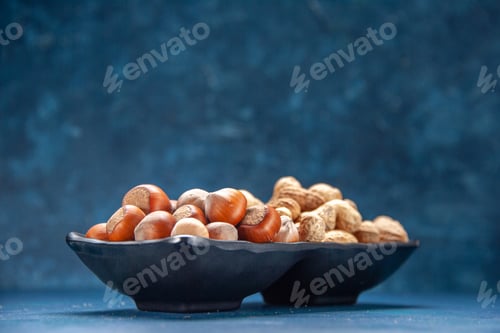 Preview: front view fresh nuts peanuts and hazelnuts inside plate on a blue background color snack cips nut