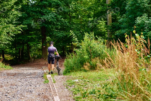 Preview: Athelete ride on bike in mountain forest.