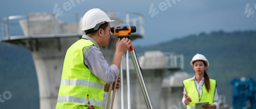 Preview: Civil engineers are taking measurements with surveying tools during the construction.