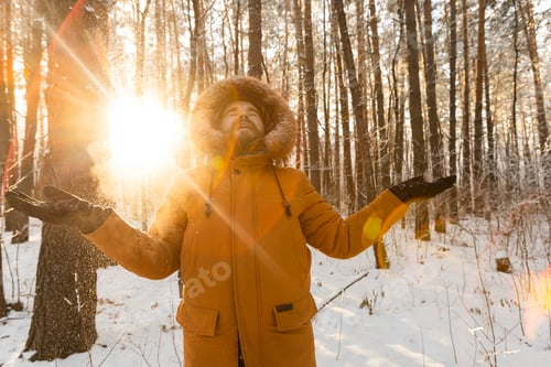 Preview: Happy bearded man in hat throws up snow in winter nature. Snowy cold season and holidays lifestyle