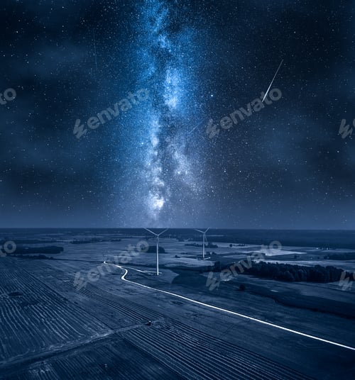 Preview: Milky way over wind turbines on field. Alternative energy, Poland.