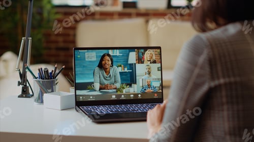 Preview: Teleworker in living room chats in teleconference call with business executives