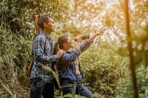 Preview: Asian couples enjoy walking with a backpack in the pine forest and watching animals by long-distance