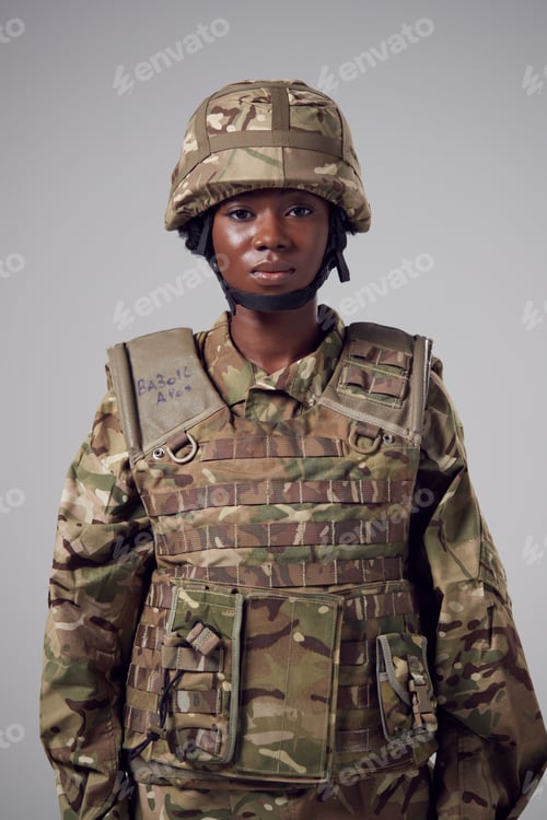 Preview: Studio Portrait Of Serious Young Female Soldier In Military Uniform Against Plain Background
