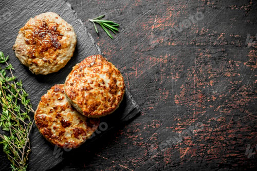 Preview: Cutlets on a black stone Board with thyme.