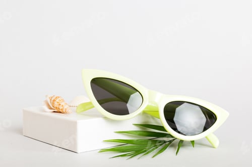 Preview: sunglasses with seashell lying on table background. Sunglasses
