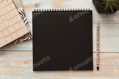 Preview: Spiral bound notepad mockup template with black paper, pencil and potted plant on wooden office desk