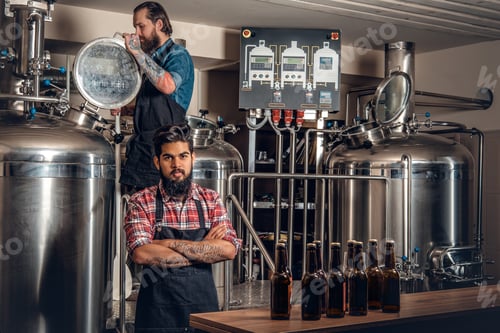 Preview: Tattooed, bearded Caucasian and Indian men in the craft beer microbrewery.
