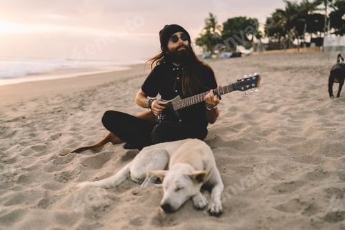 Preview: carefree man using folk guitar for playing summer music at seashore