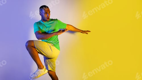 Preview: Athletic Black Male Exercising Over Blue And Yellow Background