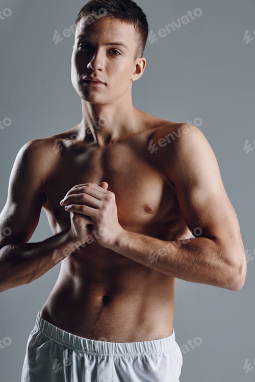 Preview: sexy athletes with inflated torso holding hands near chest on gray background