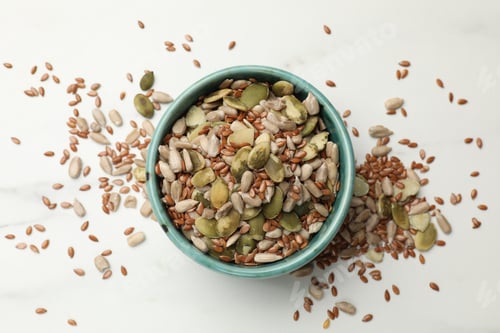 Preview: Mix of seeds in bowl on white table, flat lay