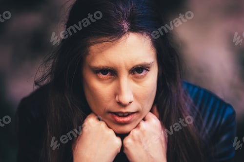 Preview: Angry and pensive adult young woman leaning head against a brick wall