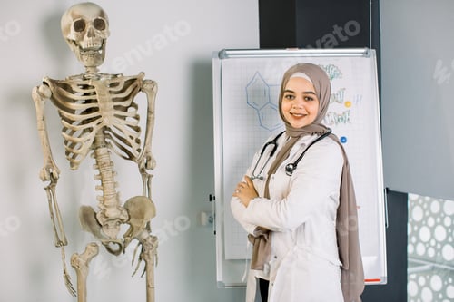 Preview: portrait of friendly, smiling muslim female doctor with stethoscope. Muslim girl medical student or