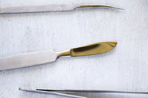 Preview: Top view of surgery blade with other dissenting kits on wooden table