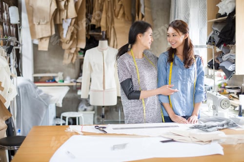 Preview: Two female fashion designers talking in studio