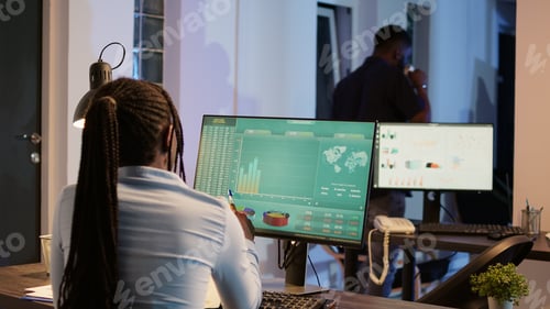 Preview: Company employee analyzing business report charts on computer