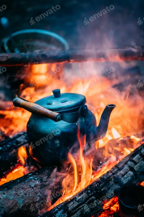 Preview: Old Retro Iron Camp Kettle Boiling Water On A Fire In Forest. Br