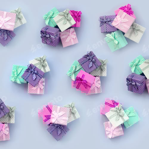Preview: Piles of a small colored gift boxes with ribbons lies on a violet background