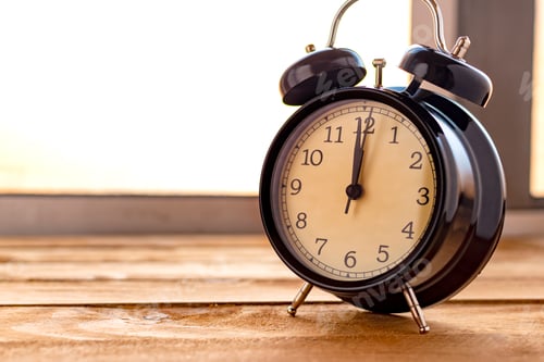 Preview: Black clock on an old wooden table.