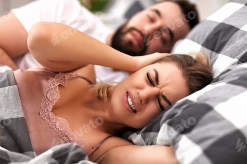 Preview: Adult couple suffering from snoring problem in bed