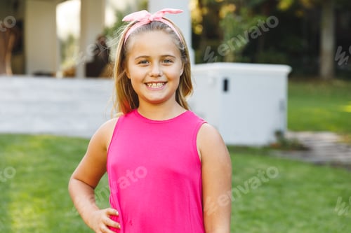 Preview: Portrait of smiling caucasian girl outside house looking at camera in garden