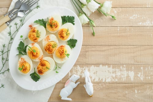 Preview: Easter stuffed eggs. Traditional Easter brunch or dinner with stuffed eggs with paprika, carrot cake
