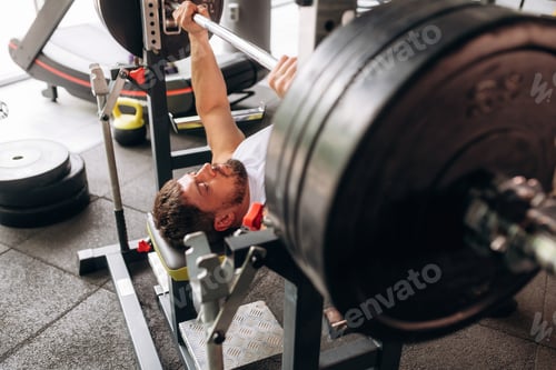 Preview: Side view, pushing the barbell. Strong man is working out in the gym